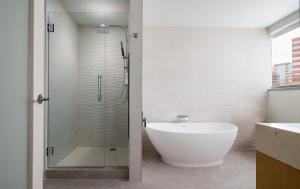 a bathroom with a shower with a tub and a sink at The Westin Houston Medical Center - Museum District in Houston