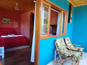 a room with a bed and a chair and a window at Pousada Fronteira in Bocaina de Minas