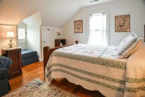 um quarto com uma cama, uma cadeira e uma janela em Love Lane Bed & Breakfast em Waynesville