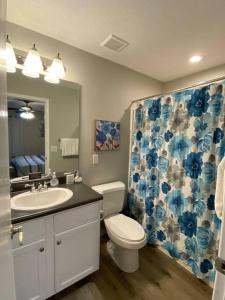 een badkamer met een toilet, een wastafel en een spiegel bij The Vista in Branson