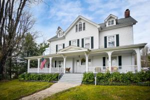 una casa blanca con una bandera americana en el porche en Love Lane Bed & Breakfast en Waynesville