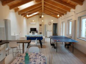 Habitación con 2 mesas de ping pong y sillas en Holydays Home LITTLE FROG en Agliano Terme