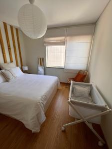 - une chambre avec un grand lit blanc et une fenêtre dans l'établissement Douro Valley Terrace Apartments, à Armamar