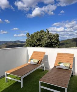 dois bancos sentados em cima de uma varanda em Douro Valley Terrace Apartments em Armamar