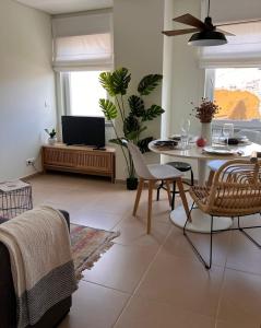 uma sala de estar com uma mesa e cadeiras e uma televisão em Douro Valley Terrace Apartments em Armamar