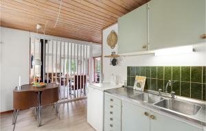 cocina con armarios blancos y techo de madera en Lovely Home In Spttrup With Kitchen, en Spottrup