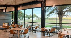 a restaurant with tables and chairs and a large window at Backland in Williams