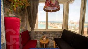 - un salon avec un canapé et une grande fenêtre dans l'établissement Gleem Bay View, à Alexandrie