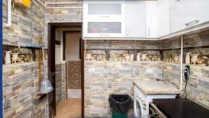 a kitchen with a brick wall with a sink and a microwave at Gleem Bay View in Alexandria