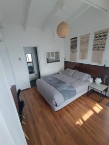 1 dormitorio con 1 cama grande y suelo de madera en Laura del Mar Hotel Boutique, en Concón