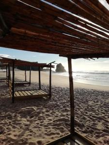 uma praia com duas camas na areia em Pé na Praia em Torres Vedras