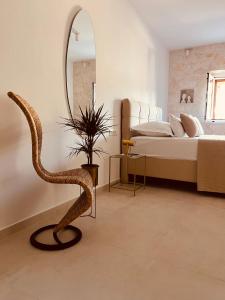 a bedroom with a snake chair and a mirror at Oleander Apartment & Room Centar in Hvar