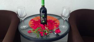 een glazen tafel met een fles wijn en twee wijnglazen bij Eko Vlasina in Vlasotince