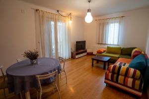 een woonkamer met een tafel en een bank bij Tri pera -- self check in in Osijek