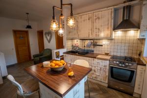 a kitchen with a bowl of oranges on a wooden island at Tri pera -- self check in in Osijek