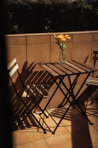 a table with a vase of flowers and a chair at San Sebastián DOT Rooms in San Sebastián