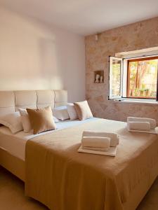 a bedroom with a large bed with towels on it at Oleander Apartment & Room Centar in Hvar
