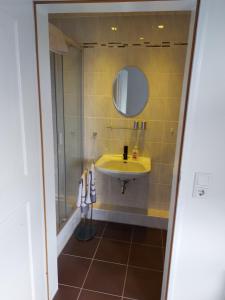 a bathroom with a yellow sink and a mirror at Apartment vor Sylt und Dänemark in Klanxbüll
