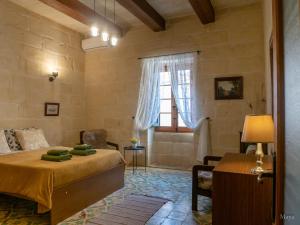- une chambre avec un lit, une table et une fenêtre dans l'établissement Id Dar Ta Censu, à Qala