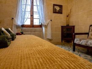 a large yellow bed in a room with a window at Id Dar Ta Censu in Qala