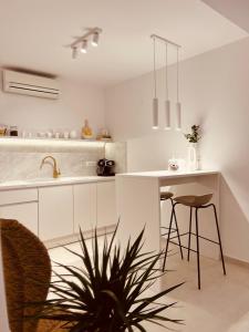 a kitchen with white cabinets and a table and chairs at Oleander Apartment & Room Centar in Hvar