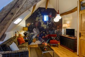 a living room with a large painting on the wall at Maison le Village - Maison d’Hôtes in Montagny-lès-Beaune