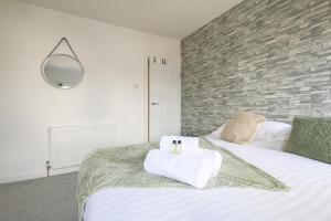 a bedroom with a bed with two towels on it at StayRight 2 Bedroom House in Pontypool near Canals- Freshly renovated in Griffithstown