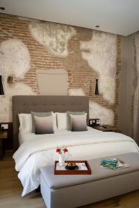 una camera con un grande letto e un muro di mattoni di Cartesiano Boutique & Wellness Hotel a Puebla