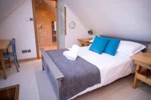a bedroom with a large bed with blue pillows at Converted Barn House - Central Oxford, Cotswolds in Cassington