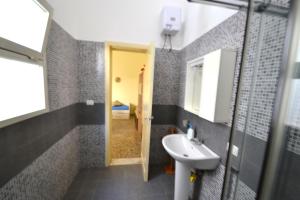 ein Badezimmer mit Waschbecken und Spiegel in der Unterkunft Ll84 Casa vacanze per 4 pax Luce in Roca Vecchia + 21 Fotos