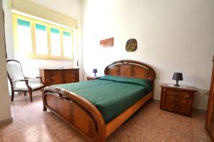 ein Schlafzimmer mit einem Bett und einem Stuhl und einem Fenster in der Unterkunft Ll84 Casa vacanze per 4 pax Luce in Roca Vecchia