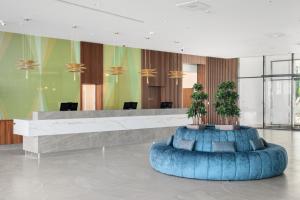 a lobby with a reception desk with two potted plants at Sirius Hotel****Superior in Keszthely