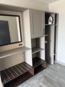 a living room with a tv and some shelves at Holiday Inn Chicago Midway Airport S, an IHG hotel in Chicago