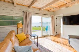 a living room with a couch and a large window at Seahorse Cottage in Indian Harbour