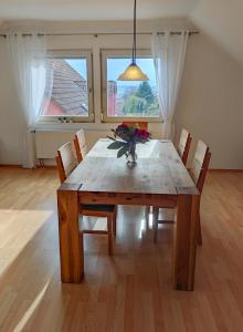 a dining room table with chairs and a vase of flowers at Fränkische Schweiz Blick in Forchheim