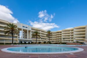 a large building with a large pool in front of it at AL - Maré in Albufeira