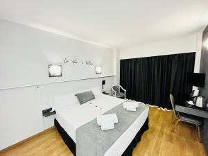 een slaapkamer met een groot wit bed en een televisie bij Princesa Solar 4* - Adults Recommended in Torremolinos