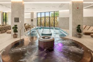 a pool in a hotel lobby with a fountain at Sirius Hotel****Superior in Keszthely