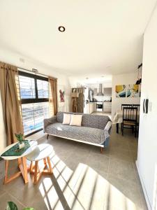 ein Wohnzimmer mit einem Sofa und einem Tisch in der Unterkunft Lumiere Apartments - Moderno Departamento en Complejo Residencial in Mendoza