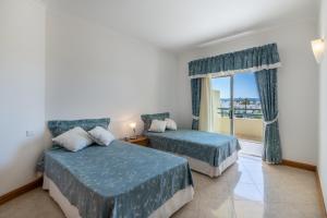 Una habitación de hotel con dos camas y una ventana. en AL - Maré, en Albufeira 25 fotos más