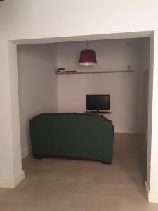 sala de estar con sofá verde y TV en Casa Azul de la Almedina de Almería en Almería