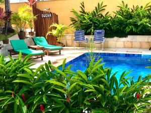 a patio with chairs and a swimming pool at Pousada Aconchego da Pipa in Pipa