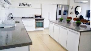 a kitchen with white cabinets and a counter top at על קצה ההר in Yoqne‘am