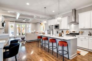a kitchen with white cabinets and a island with bar stools at Nell's Haven Two Miles To Downtown & Broadway in Nashville