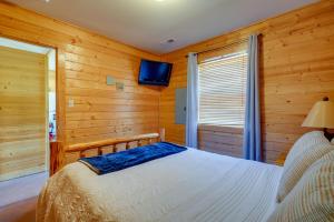 a bedroom with a bed and a tv on the wall at Lakefront Vacation Rental with Patio and Grill! in Columbia