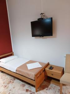 1 dormitorio con 1 cama y TV en la pared en CASA VACANZE LINA, en San Mauro Castelverde