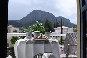 uma mesa com um prato de comida numa varanda em Vasilios Marinos Rooms em Corinto