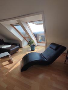 a living room with a black couch in the middle of a room at Fränkische Schweiz Blick in Forchheim