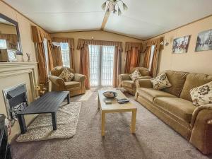 sala de estar con sofá y mesa de centro en Lovely Caravan With Large Decking At Naze Marine Holiday Park Ref 17306br, en Walton-on-the-Naze