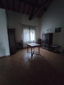 ein Zimmer mit einem Tisch in der Mitte eines Zimmers in der Unterkunft Rod Ranch Livestock - Stanza matrimoniale in clubhouse in Campagnano di Roma